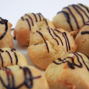 Profiteroles al cioccolato ripieni di di crema chantilly